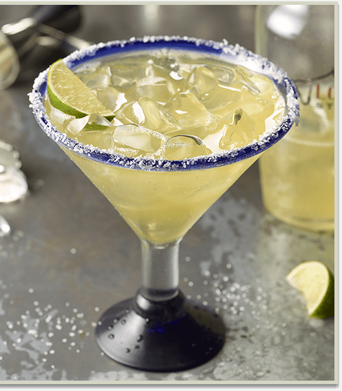 Margarita on the rocks with limes beside it