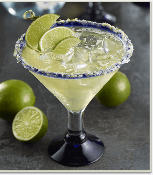 Margarita on the rocks with limes beside it