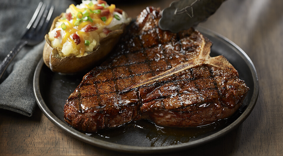 Picture of a steak being placed on a plate