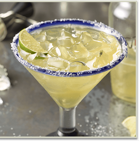 Margarita on the rocks with limes beside it