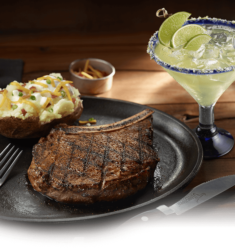 Image of a steak, baked potato, and margarita.