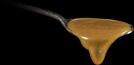 Silver spoon with caramel dripping out of it