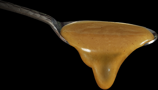 Silver spoon with caramel dripping out of it