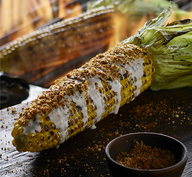 The LongHorn Fire-Grilled Corn On The Cob with crema and parmesan cheese.